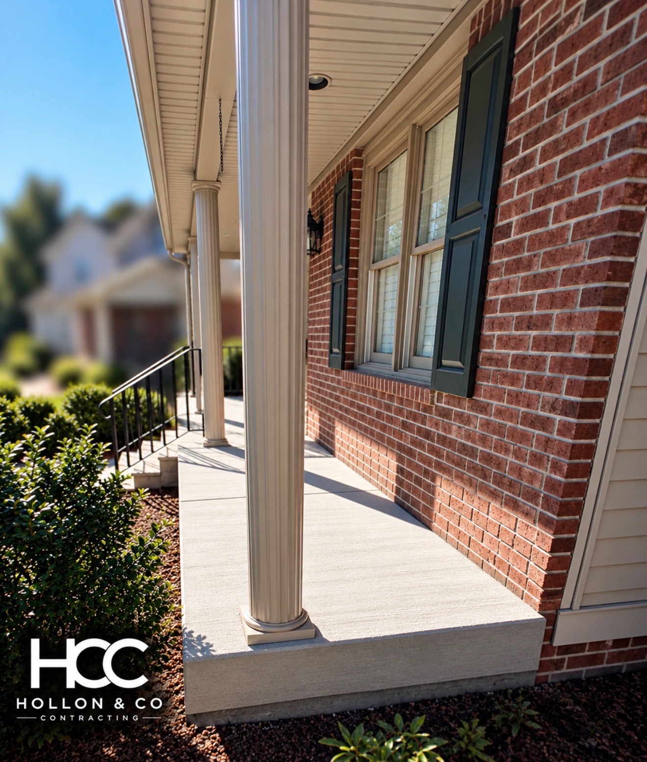 Concrete front porch with white columns and steps, completed by Hollon & CO. Contracting