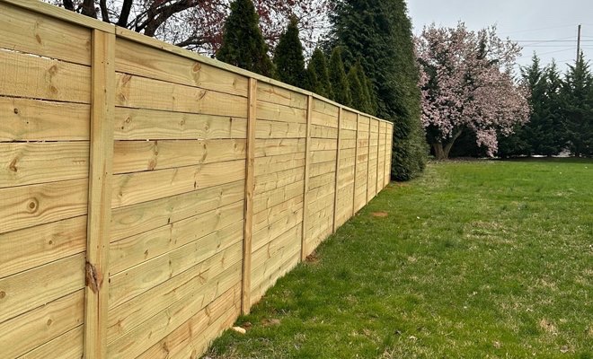 Wooden privacy fence bordering a green residential yard