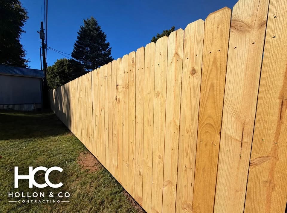 Close view of wooden privacy fence pickets, with the Hollon and Co logo