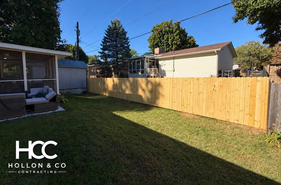 Wooden privacy fence across a backyard, with the Hollon and Co logo